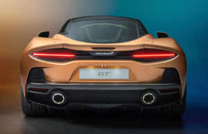 金色McLaren GT跑車後視圖，紅色尾燈，工作室拍攝。 — 福特 壁紙