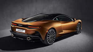 金色McLaren跑車，黑色車頂和車輪，在黑暗的工作室環境中。 — 福特 壁紙