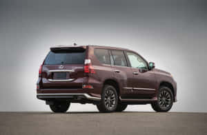 酒紅色 Lexus GX SUV 攝影棚拍攝，從後方四分之三角度。 — Surface Pro 壁紙