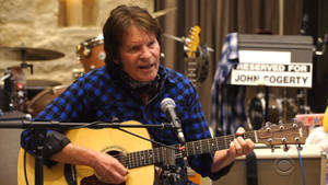 John Fogerty 以木吉他和麥克風現場表演。 — 音樂 壁紙