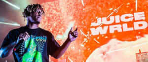 Juice WRLD 在舞台上現場表演，帶有發光的橙色背景和他的名字顯示。 — 美學音樂 壁紙