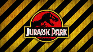 Jurassic Park 標誌，紅色背景上有一隻 T-Rex 剪影，並帶有黃色和黑色危險條紋。 — 侏羅紀世界：統霸天下 壁紙