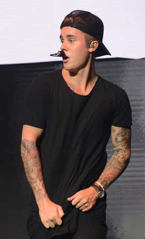 Justin Bieber 在舞台上唱歌，手臂上的刺青清晰可見。 — Galaxy Tab S10 Ultra 壁紙