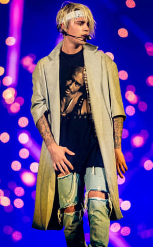 Justin Bieber 在舞台上表演，背後有紫色和粉紅色燈光。 — 小賈斯汀 壁紙