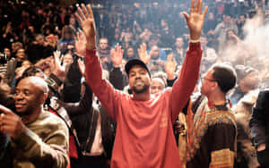Kanye West 在現場演唱會中於歡呼的人群中舉起雙手。 — 肯伊·威斯特 壁紙