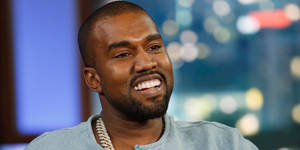 Kanye West 在訪問中穿著藍色襯衫，戴著金鏈微笑。 — 肯伊·威斯特 壁紙
