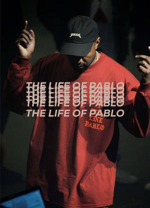 Kanye West 穿著紅色運動衫和黑色帽子表演，疊加專輯標題。 — 肯伊·威斯特 壁紙