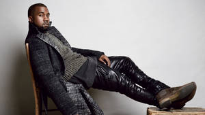 Kanye West 坐在木椅上，穿著質感外套和皮褲。 — 肯伊·威斯特 壁紙