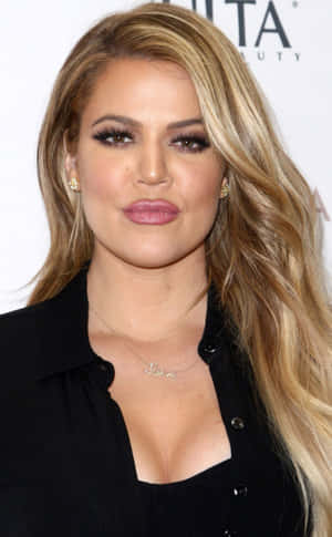 Khloé Kardashian 在美容活動中穿著黑色襯衫和項鍊。 — OnePlus Pad Lite 壁紙