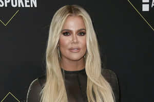 Khloé Kardashian 在一個華麗的活動中穿著黑色服裝搭配金色點綴。
