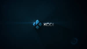 Kodi 媒體播放器標誌，在黑暗背景上帶有藍色光芒和鏡頭光暈。 — 科迪 壁紙