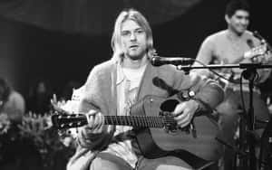Kurt Cobain 在舞台上以木吉他現場表演的黑白影像。 — 涅槃 壁紙