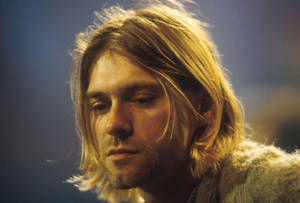 Kurt Cobain 在近距离肖像中，头发凌乱，表情严肃。