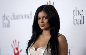 Kylie Jenner 在 The Diamond Ball 穿著白色連衣裙，背景有紅色手印標誌。 — 凱莉·珍娜 壁紙