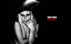 Lady Gaga 戴著幾何帽子，妝容大膽，並有文字寫著「The Queen」。 — 瑪丹娜 壁紙