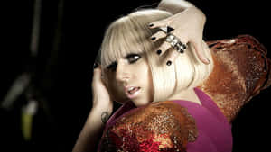 Lady Gaga 身穿亮片服裝，雙手靠近臉龐，背景深色。 — 女神卡卡 壁紙