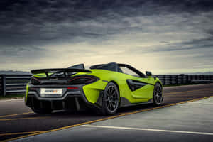 萊姆綠色McLaren 600LT Spider在賽道上，天空多雲。 — MacBook Pro M4 壁紙