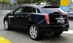 黑色Cadillac SRX SUV停泊在鵝卵石街道上。 — 凱迪拉克 壁紙