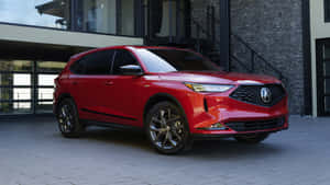 紅色Acura SUV停放在現代石頭和玻璃建築前。 — Pro Display XDR 壁紙
