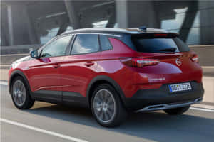 紅色Opel Grandland X SUV在白天行駛於橋上。 — 歐寶 壁紙