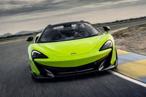 萊姆綠色McLaren 570S敞篷跑車在賽道上比賽，駕駛員戴著頭盔。 — MacBook Pro M3 壁紙