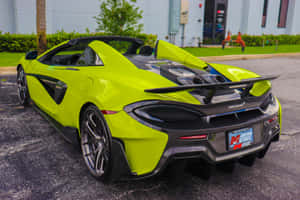 青檸綠色McLaren跑車停放在建築物和棕櫚樹附近的戶外。 — MacBook Air 13 壁紙