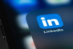 LinkedIn 應用程式圖標顯示在智慧型手機螢幕上，背景模糊。 — 領英 壁紙
