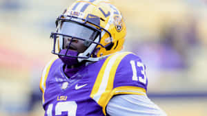 LSU 足球員身穿紫色和金色球衣，號碼13。 — 運動風 壁紙