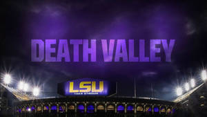 LSU老虎體育場在夜晚被照亮，上方有發光紫色的「DEATH VALLEY」文字。 — LSU 壁紙