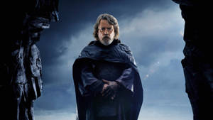 Luke Skywalker 身穿深色斗篷站在暴風雨天空下的岩石裂縫中 — 星際大戰 壁紙