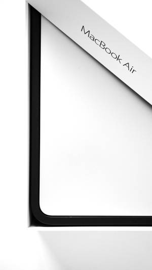 MacBook Air 筆記型電腦角落的特寫，採用白色和黑色設計。 — MacBook Air 壁紙