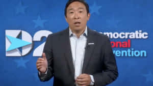 身穿西裝的男子在藍色星星背景的民主黨全國代表大會活動中發言。 — 政治 壁紙