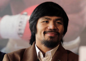 Manny Pacquiao 在記者會上穿著棕色外套微笑。