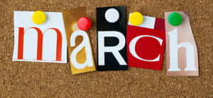 色彩繽紛的剪出字母拼出「March」，用圖釘釘在軟木板上。 — 冬季風景 壁紙