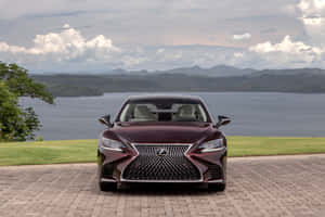 栗色Lexus轎車停在磚砌車道上，俯瞰湖泊和山脈。 — Surface Pro 壁紙