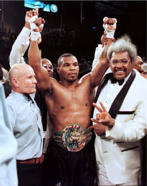 Mike Tyson 在拳擊擂台上手持冠軍腰帶並高舉拳頭取得勝利。 — 麥克·泰森 壁紙
