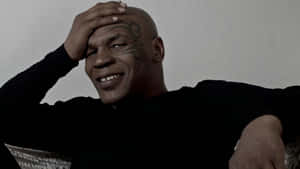 Mike Tyson 穿著黑色毛衣，手放在頭上微笑。 — 麥克·泰森 壁紙