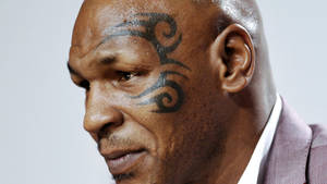 身穿西裝的 Mike Tyson，他標誌性的面部紋身清晰可見。 — 刺青 壁紙