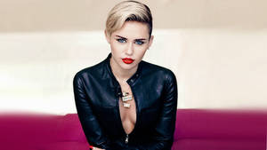 Miley Cyrus 身穿黑色皮夾克，紅唇，坐在洋紅色沙發上 — 麥莉·希拉 壁紙