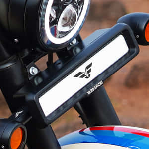 機車在沙漠環境中的前燈及品牌面板特寫。 — 巴布風機車 壁紙