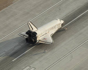 NASA太空梭發現號在混凝土跑道上，附近有人。 — 伸展台 壁紙