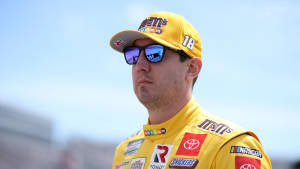 NASCAR車手穿著黃色M&M's制服，在戶外戴著太陽眼鏡。 — 運動 壁紙