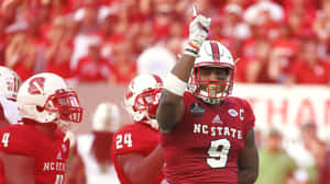 NC State 足球運動員 9 號在比賽中高舉拳頭慶祝勝利。 — 運動 壁紙
