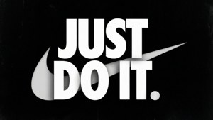 Nike 標語 'Just Do It' 以粗體白色字母和勾號標誌顯示在黑色背景上。 — 省電 壁紙