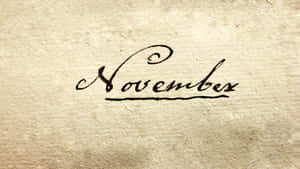 在紋理米色紙上以黑色墨水手寫的「November」一詞。 — 可愛萬聖節桌面 壁紙