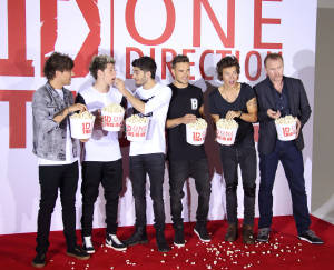 One Direction 樂團成員在活動的紅地毯上手持爆米花桶。 — 5:4 壁紙