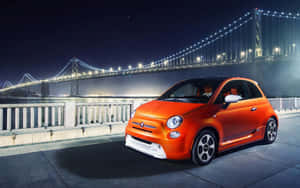 夜間停泊在亮燈吊橋附近的橙色Fiat 500。 — Steam Deck 壁紙