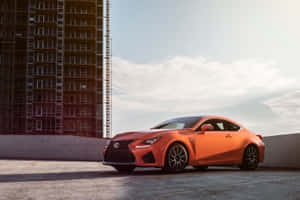 橙色Lexus跑車在日落時停放在屋頂，靠近建築工地。 — Surface Pro 壁紙