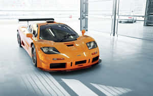 橙色McLaren F1超級跑車在乾淨的現代車庫中，帶有強烈陰影。 — Steam Deck 壁紙