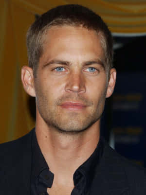 Paul Walker 身穿深色西裝，藍眼睛、鬍渣，看著相機。 — 保羅·沃克 壁紙